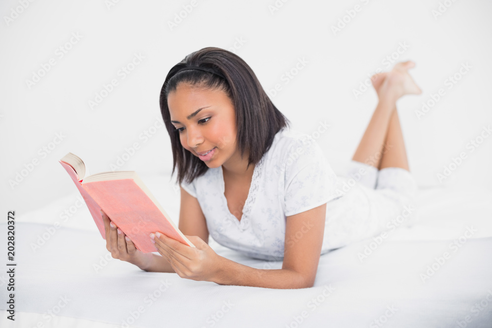 Concentrated young dark haired model reading a book Concentrated young dark haired model reading a book