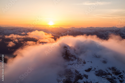 Striking and beautiful aerial landscape view of Canadian Mountains during a vibrant sunsetd. Taken North of Vancouver, British Columbia, Canada.