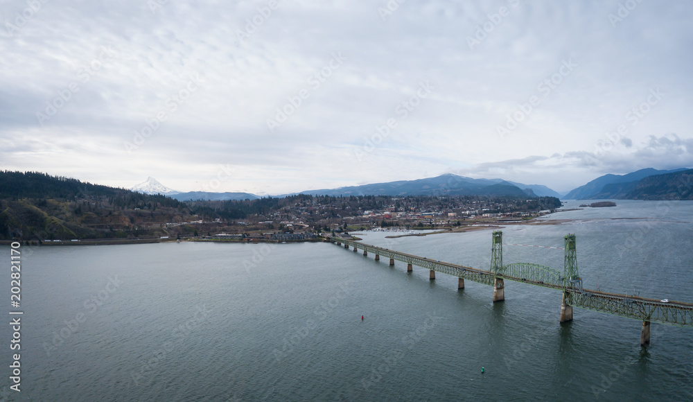 Aerial panorama of a bridge going over Columbian River between Oregon and Washington during a winter day.