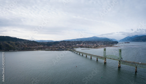 Aerial panorama of a bridge going over Columbian River between Oregon and Washington during a winter day.