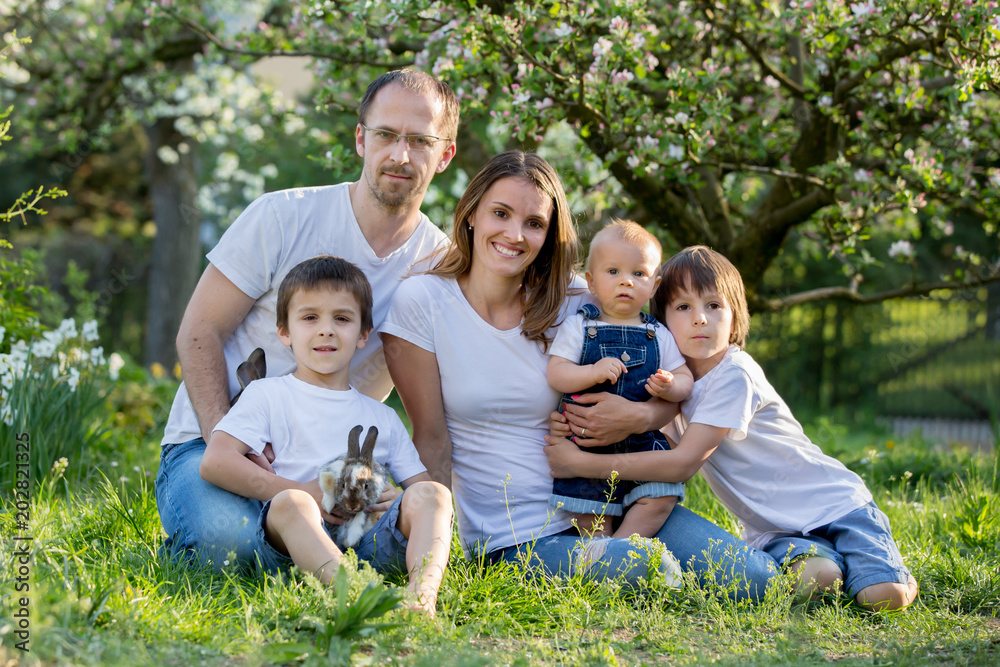 Fashionable big family, having their spring portrait taken with little bunnies Fashionable big family, having their spring portrait taken with little bunnies