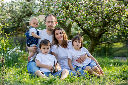 Fashionable big family, having their spring portrait taken with little bunnies © Tomsickova