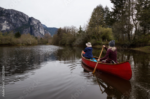 Couple adventurous friends canoeing on the lake with Chief Mountain in the background. Taken in Squamish North of Vancouver  British Columbia  Canada.
