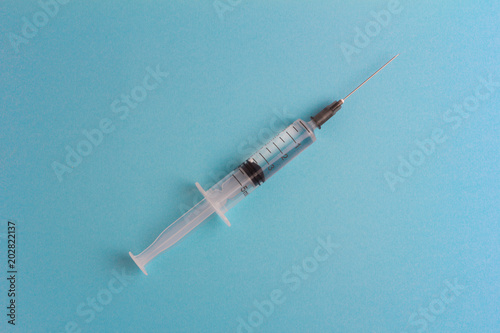 Syringe with medication on a blue background