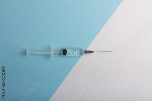syringe with medication on a diagonal white blue background