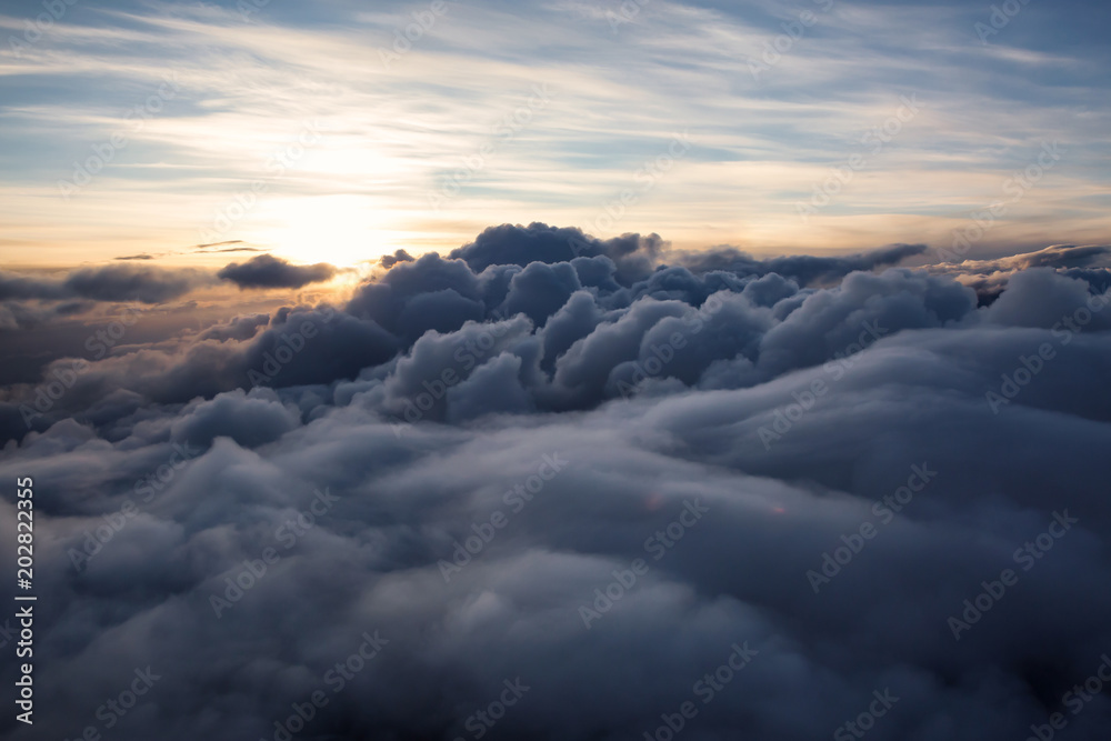Beautiful and striking aerial view of the puffy clouds during a colorful sunset. Taken near Vancouver, British Columbia, Canada.
