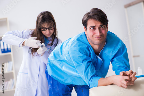 Funny man getting ready for buttocks syringe shot