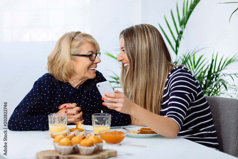Happy mother and daughter taking a selfie at breakfast. Mother's Day concept Happy mother and daughter taking a selfie at breakfast. Mother's Day concept