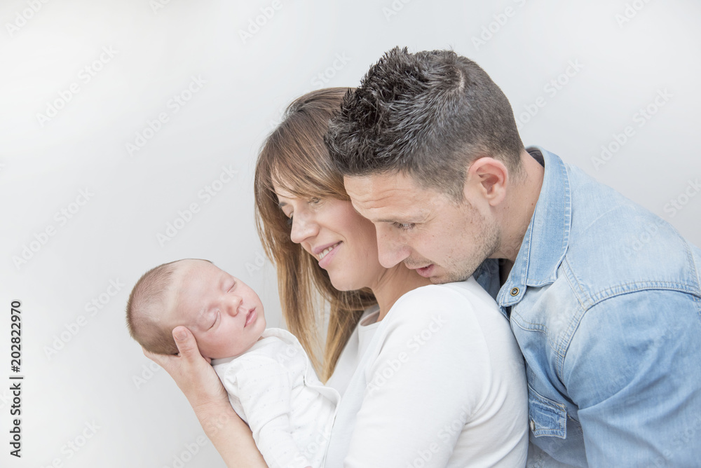 Young Couple Posing Happy with their first child Young Couple Posing Happy with their first child