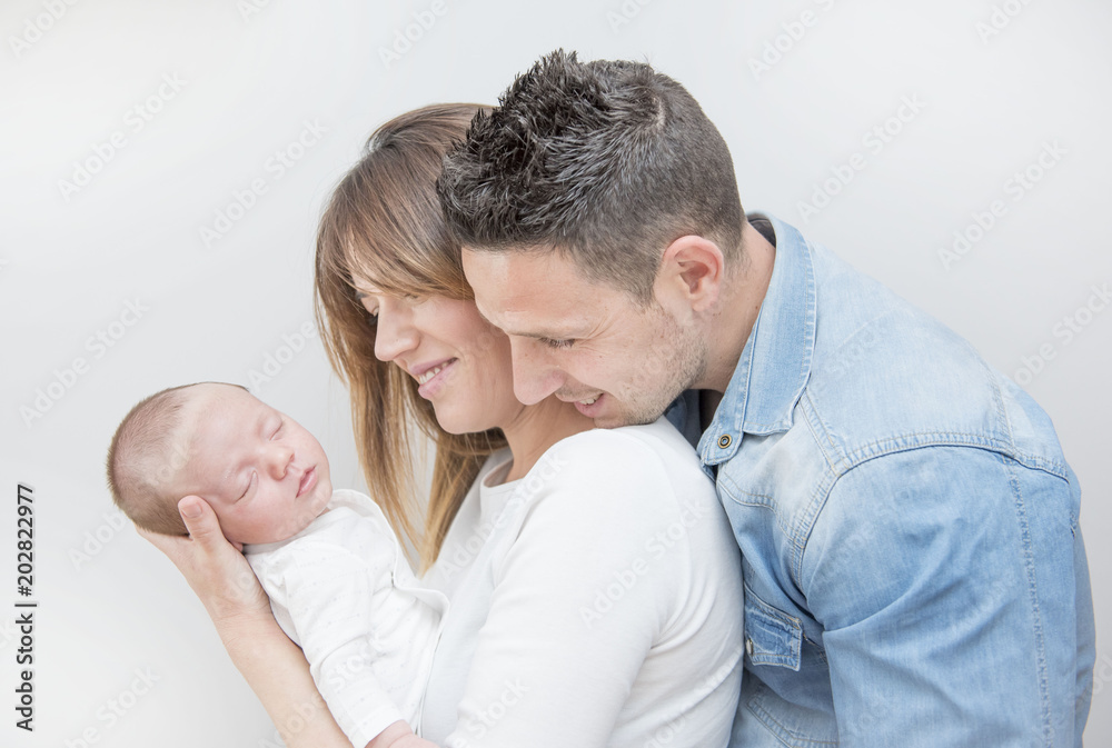 Young Couple Posing Happy with their first child Young Couple Posing Happy with their first child