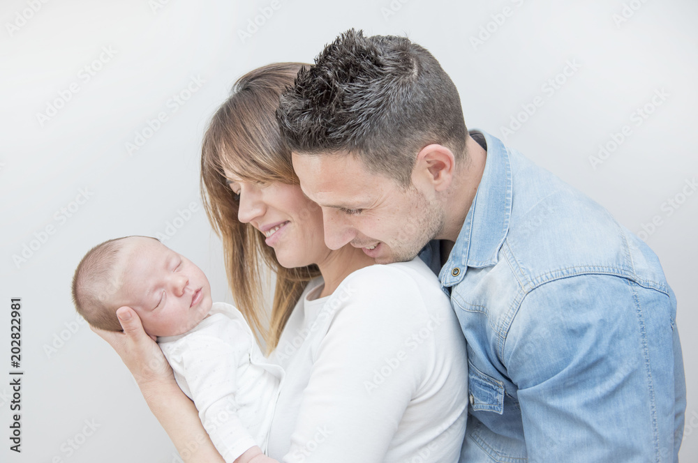 Young Couple Posing Happy with their first child Young Couple Posing Happy with their first child