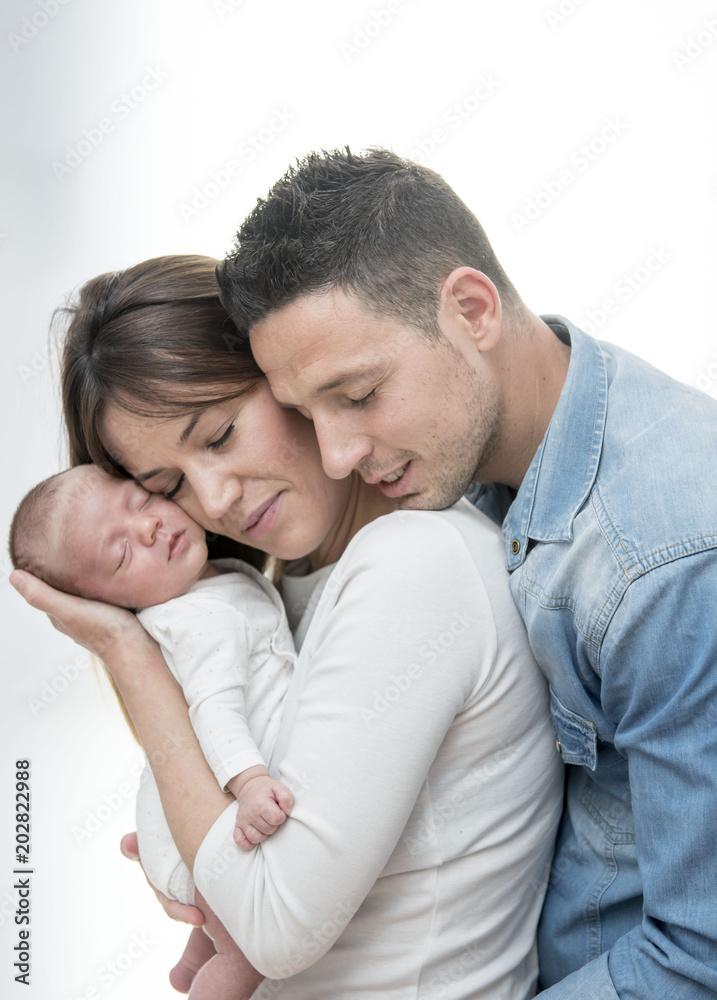 Young Couple Posing Happy with their first child Young Couple Posing Happy with their first child