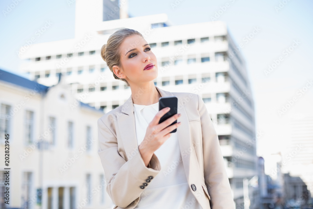 Pensive attractive businesswoman sending a text message Pensive attractive businesswoman sending a text message