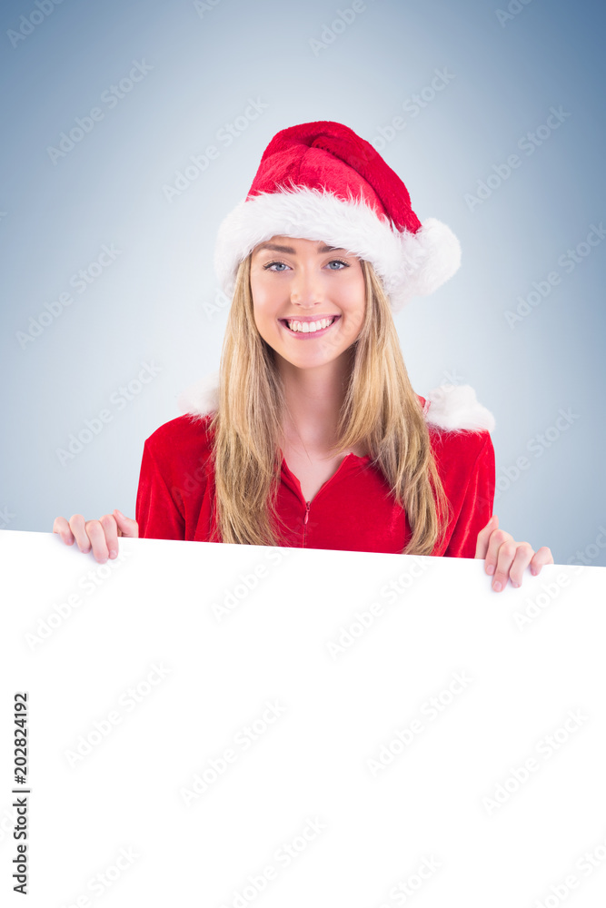 Pretty santa girl smiling at camera with poster on vignette background