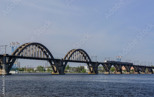 Suburban passenger train on the Merefa-Kherson bridge across the Dnieper River © Sergey T..