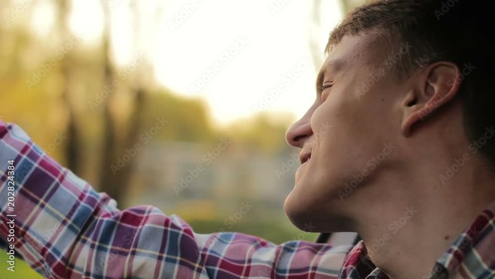 Happy guy smiling enjoying the journey by car. he smiles and enjoys the view sunny evening city Happy guy smiling enjoying the journey by car. he smiles and enjoys the view sunny evening city