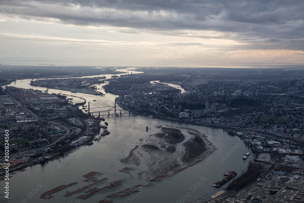 Aerial view of Fraser River during a cloudy sunset. Taken in Greater Vancouver, British Columbia, Canada.