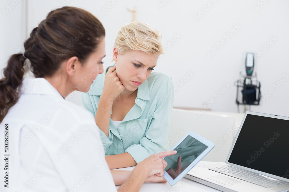 Fototapeta premium Doctor using tablet pc with her patient