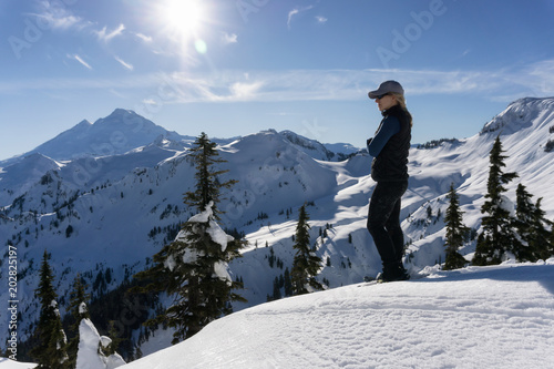 Adventurous woman is snowshoeing in the beautiful mountainous landscape. Taken in Artist Point, Northeast of Seattle, Washington, United States of America.