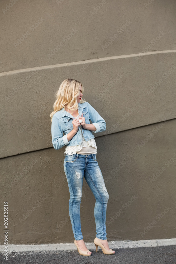 Casual blonde wearing denim clothes posing outdoors Casual blonde wearing denim clothes posing outdoors
