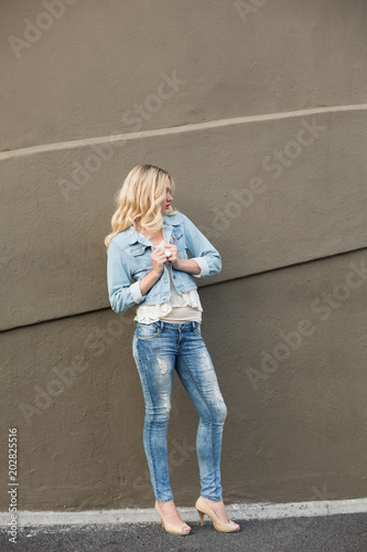 Casual blonde wearing denim clothes posing outdoors