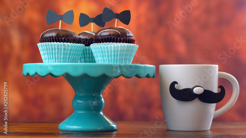 Happy Father's Day close up of cupcakes and coffee mug against rustic wood background. photo