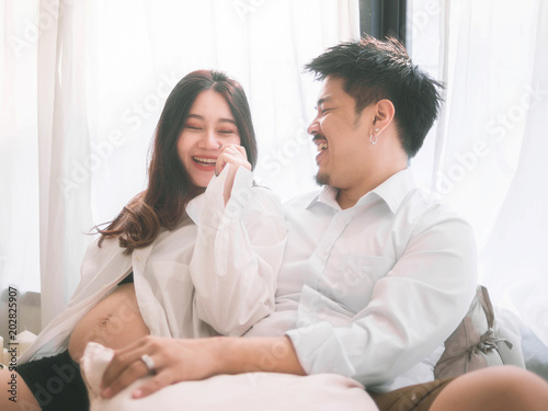 Asian man husband take care of his pregnant wife.Beautiful pregnant woman and her handsome husband are smiling while spending time together.