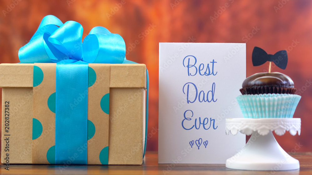 Φωτογραφία Happy Father's Day close up of gift, cupcake and card against rustic wood background
