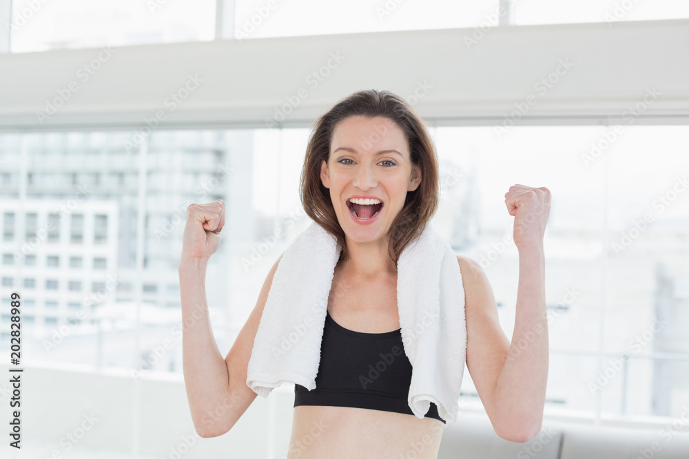 Cheerful woman clenching fists in fitness studio Cheerful woman clenching fists in fitness studio