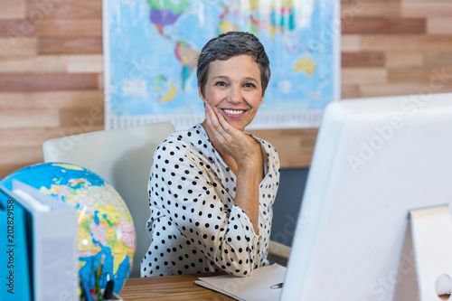 Smiling businesswoman sitting at her desk photo