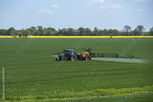 the tractor sprays the field with fertilizer