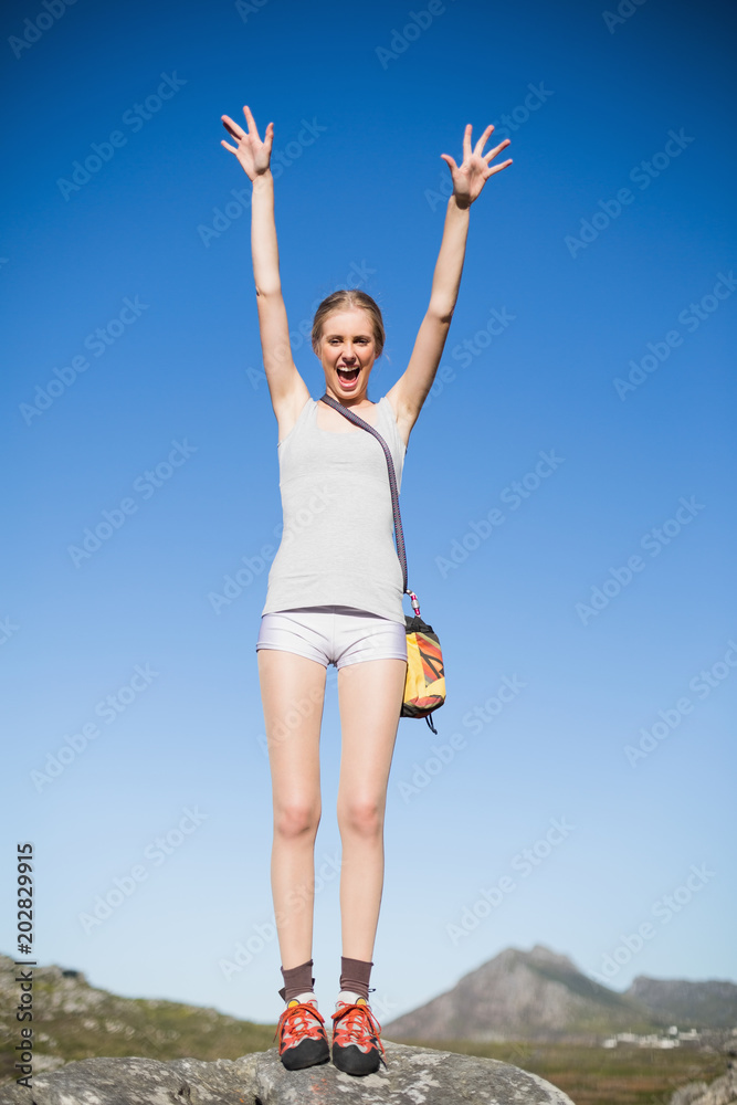 Active woman standing on rock cheering