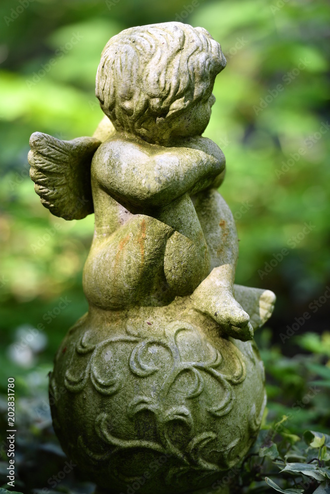 With moss covered sculpture of an angel With moss covered sculpture of an angel