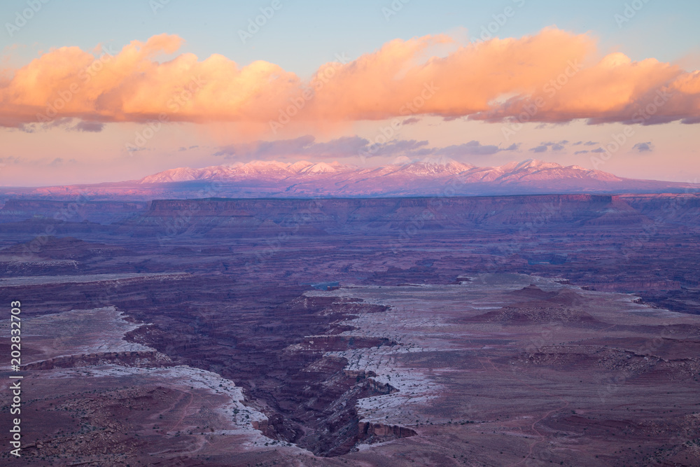 Canyonlands National Park Island in the Sky overlook of the White Rim and the La Sal Mountains near Moab, Utah at sunset with clouds