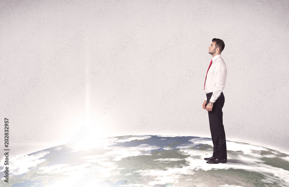 Obraz premium A young elegant office worker standing on top of a drawn world globe while celebrating his successful career concept.