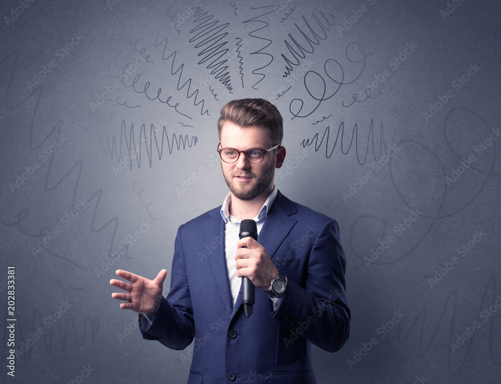 Businessman speaking into microphone with scribbles over his head Businessman speaking into microphone with scribbles over his head