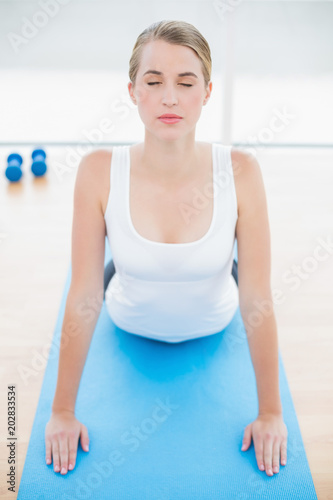 Relaxed fit woman stretching on sport mat