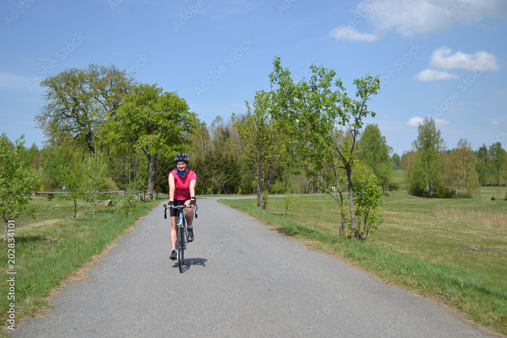 Happy young girl on bike riding through the nice landscape during beautiful spring day Happy young girl on bike riding through the nice landscape during beautiful spring day