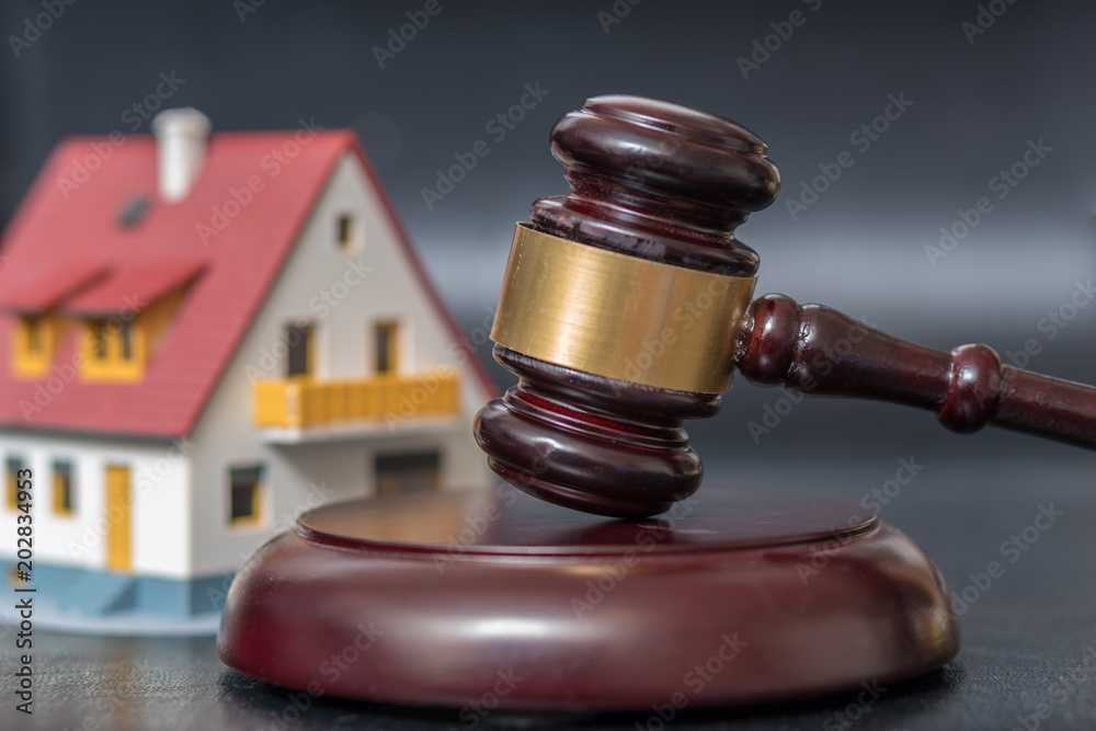 House auction concept. Gavel in front of a house model. House auction concept. Gavel in front of a house model.