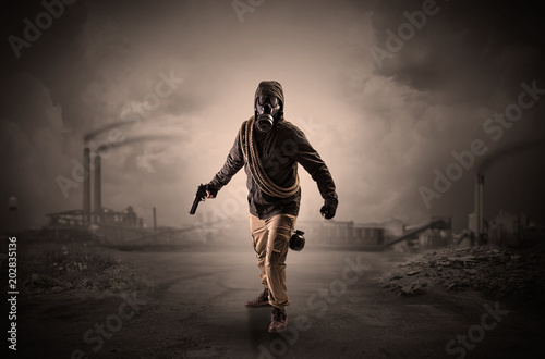 Gas masked survival man coming with arms on his hand in a demolished dark environment 