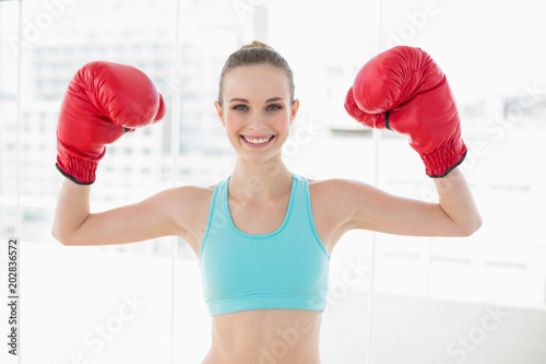Sporty smiling woman holding up boxing gloves photo