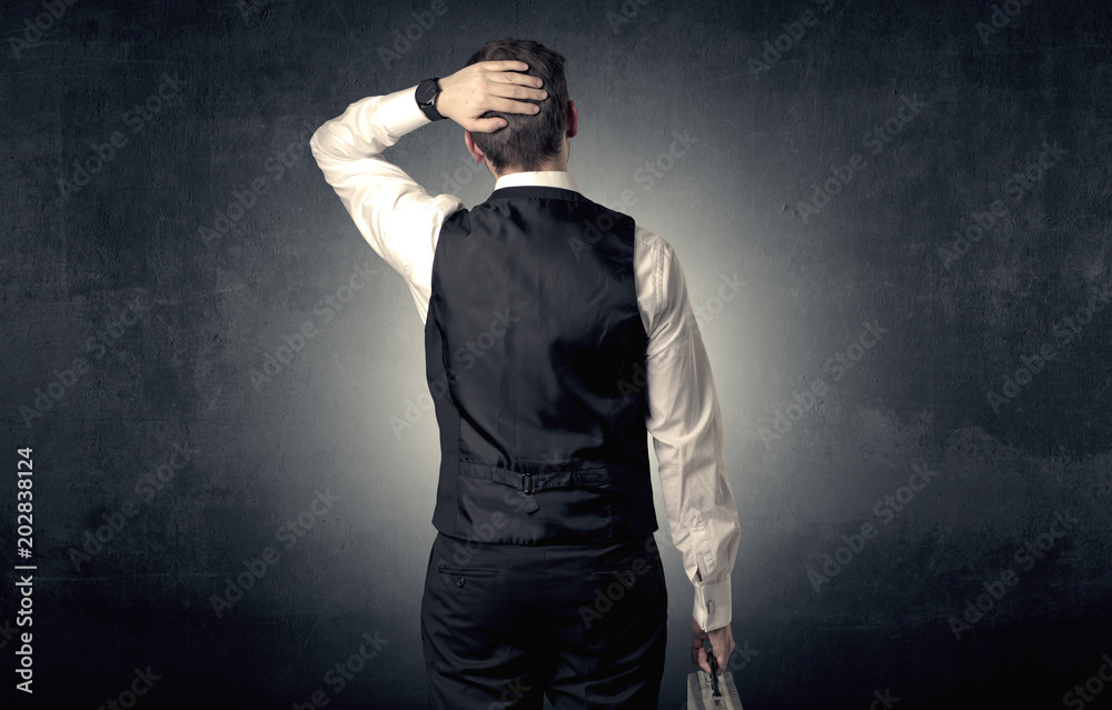 Young businessman standing and thinking alone