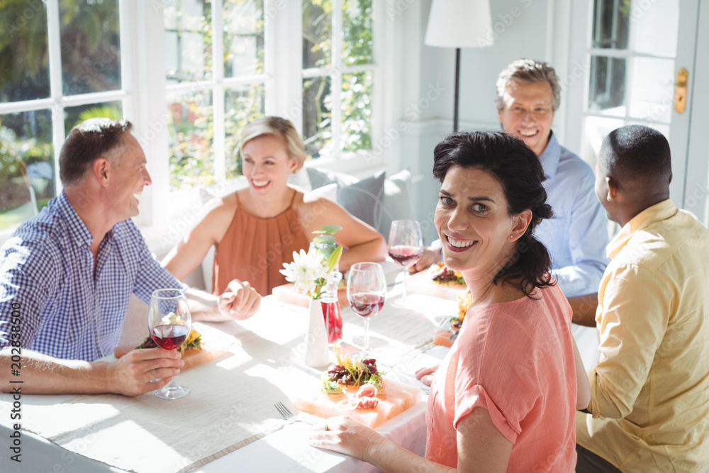 Portrait of smiling woman having meal with friends