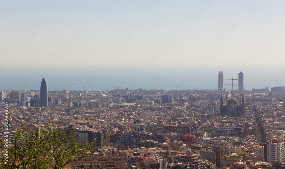 Splendid views of the city of Barcelona from top of Park Guell with Mediterranean Sea on the background