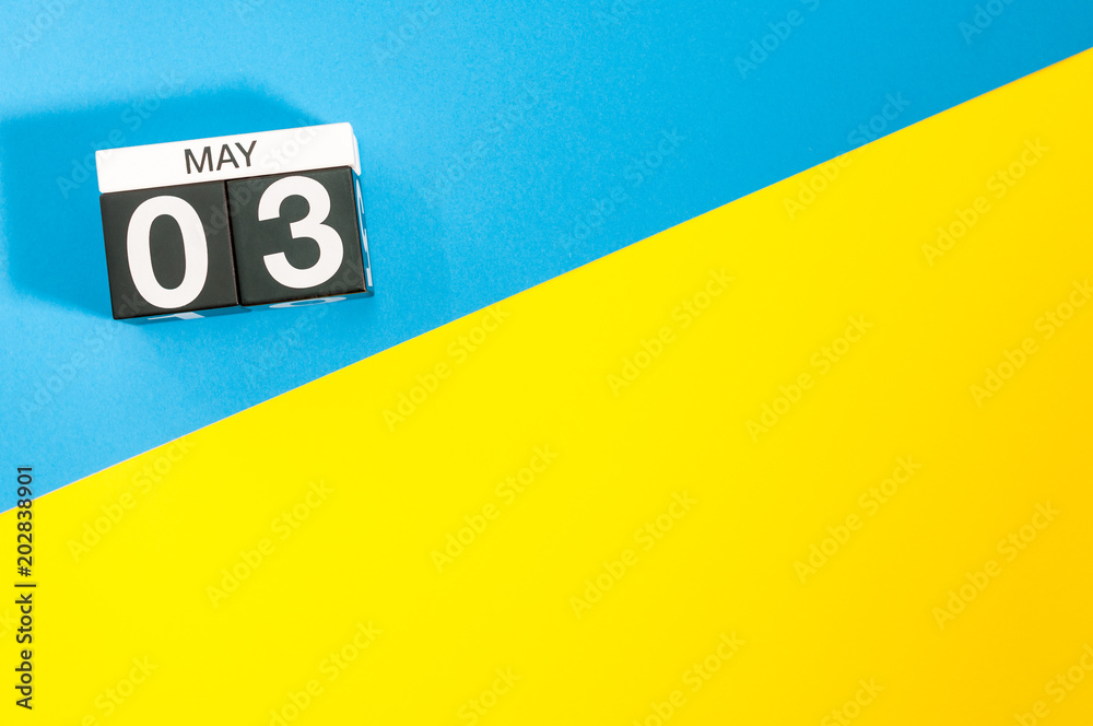 May 3rd. Day 3 of may month, calendar on blue and yellow background flat lay, top view. Spring time. Empty space for text May 3rd. Day 3 of may month, calendar on blue and yellow background flat lay, top view. Spring time. Empty space for text