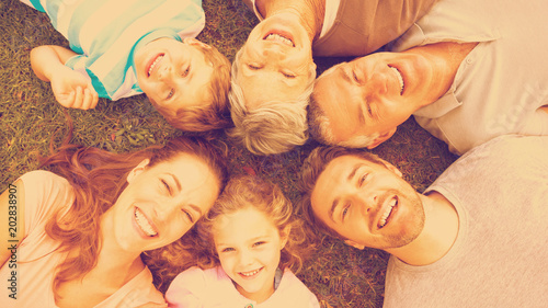 High angle portrait of an extended family lying in circle at the park