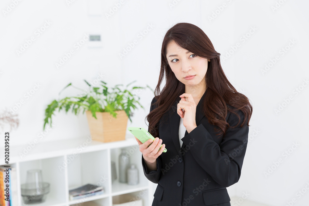 スマートフォンを見る女性　ビジネス　考える