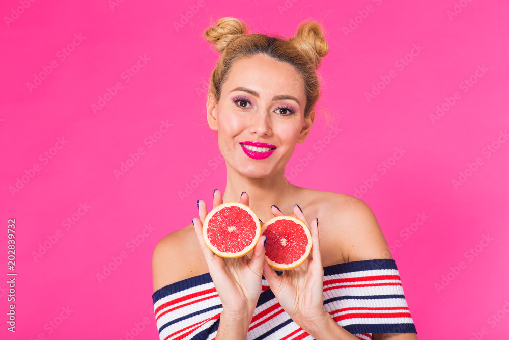 Portrait of happy girl holding halves of orange near face Portrait of happy girl holding halves of orange near face