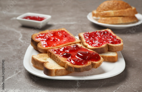 Tasty toasts with jam on plate, closeup