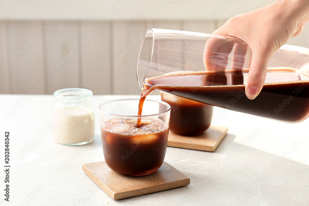 Ταπετσαρία Woman pouring cold brew coffee into glass on table